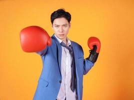 imagen de un joven empresario asiático enojado con guante de boxeo foto