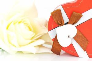 Close up white rose and heart shaped box on white photo