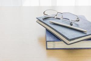 libro negro con gafas y bolígrafo foto