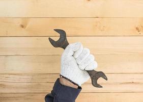 Hand in glove holding spanner photo