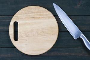 Close up kitchen knife and wooden round cutting board photo