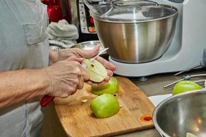 chef corta manzanas para hacer un pastel de manzana. receta paso a paso foto