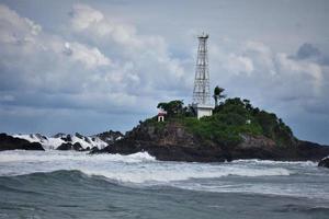 lighthouse landscape and wave on the beach photo