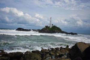 lighthouse landscape and wave on the beach photo