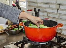 Finished bouquet of greens is placed in saucepan for dressing the dish photo