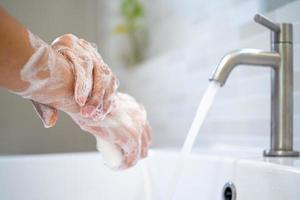 lavarse las manos con agua y jabón. las mujeres frotan jabón de manos con lavabo. el concepto de higiene de manos y días de lavado de manos en todo el mundo. reducir la acumulación de bacterias y virus. foto