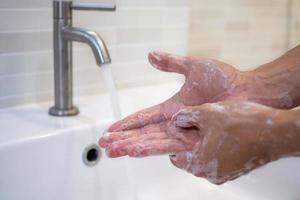 Wash hands with soap and wash with running water. Close up of women scrub hand soap with wash basin .The concept of hand hygiene and hand washing days around the world. Reducing infection Covit-19 photo