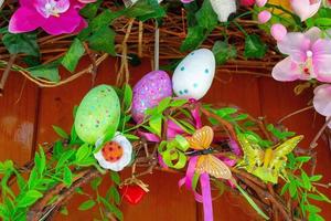 Easter Eggs wreath with flowers on front door. Traditional decoration for Easter. photo