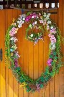 Easter Eggs wreath with flowers on front door. Traditional decoration for Easter. photo