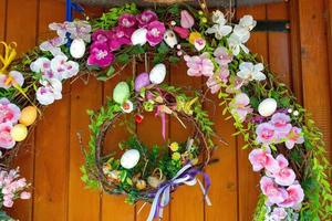 corona de huevos de pascua con flores en la puerta principal. decoración tradicional para pascua. foto