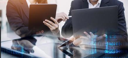 hombre de negocios asiático y mujer hermosa joven que trabajan en una tableta digital de pie fuera del edificio de oficinas. foto