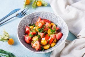 Appetizing salad with physalis, tomatoes and dill in a bowl. Vegetarian diet. photo