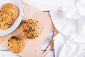 A stack of homemade oatmeal raisin cookies tied with string on a board. Healthy baking. Top view photo