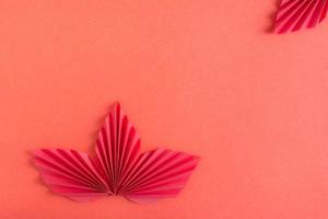Red orgami leaves on a red background. Monochrome background. Copy space photo