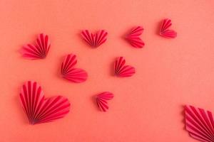 Monochrome red background with flying origami hearts. St. Valentine's Day photo