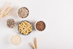 quinoa, sésamo, garbanzos, semillas de girasol y semillas de lino en los tazones. comida sana. vista superior. foto
