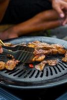 grilling sliced meat and meatballs - potrait photo