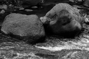 piedras negras en el río - naturaleza de fondo foto