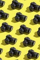 patrón de muchas cámaras fotográficas sobre fondo de color. concepto del día mundial de la fotografía foto