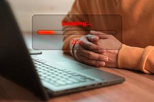 Man using laptop for download software and waiting to loading digital business data form website, concept of waiting for load of loading bar. photo