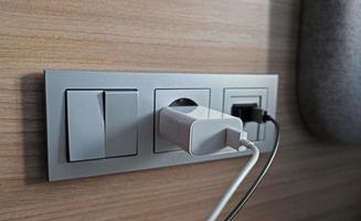 Electrical power socket, usb socket, light switch on the wood panel in the interior of the hotel. For convenience, the mobile charger or smartphone in the concept of modern life. Close up. photo