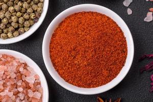 Composition consisting of variations of spices in white bowls and metal spoons photo