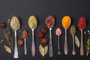 Composition consisting of variations of spices in white bowls and metal spoons photo