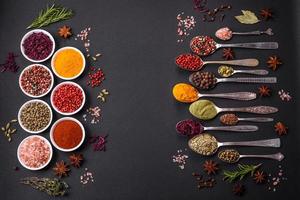 Composition consisting of variations of spices in white bowls and metal spoons photo