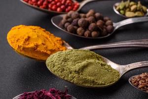 Composition consisting of variations of spices in white bowls and metal spoons photo