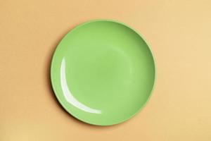 One green empty plate in center of beige background with copy space. Mock up. photo