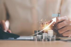 Human hand putting money on a stack of coins,and graphs showing increasing profits and business growth, Concepts of progress in improving financial efficiency and investment photo
