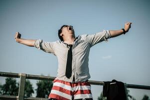 Young Asian Businessman Yawning and spreading arms for lazy twists photo