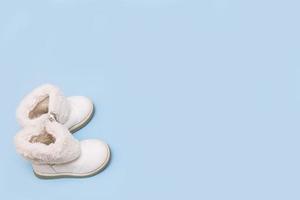 children's white boots on a blue background with copy space photo