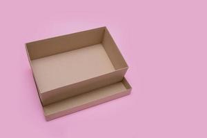 abra la caja vacía sobre fondo rosa foto