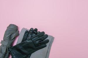 gray gloves, umbrella and scarf on a pink background with copy space photo