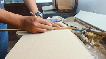 Carpenter making a wooden board with a yellow pen on his desk photo