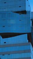 Modern building with blue glass windows reflected sky. Background in vertical format photo