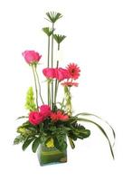 Floral gift arrangement made with red roses with long stems inside a glass pot on white background photo