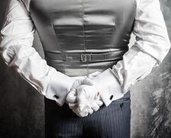 Closeup of Butler or Waiter in White Gloves Standing With Hands Behind Back. Concept of Service Industry and Elegant Hospitality. photo