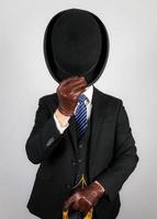 Portrait of British Businessman in Dark Suit and Umbrella Politely Doffing Bowler Hat. Classic Manners of English Gentleman. photo