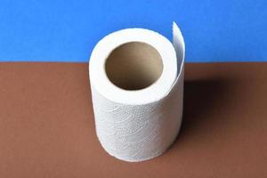 Roll of toilette paper on brown and blue background photo