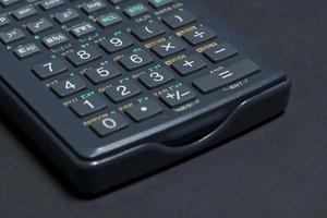 Scientific calculator isolated on black paper background photo