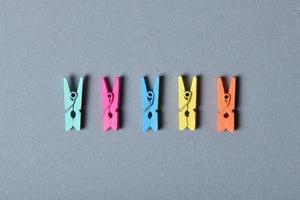 Multicolor wooden clothespins isolated on gray background photo