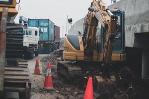 Jakarta, Indonesia in July 2022. A mini excavator is digging a roadside drainage channel photo