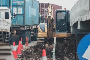 yakarta, indonesia en julio de 2022. una miniexcavadora está cavando un canal de drenaje en la carretera foto