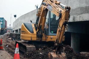 Jakarta, Indonesia in July 2022. A mini excavator is digging a roadside drainage channel photo