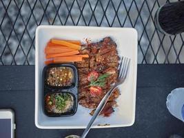 Thai style Grilled Pork Neck with Spicy Dipping Sauce . photo