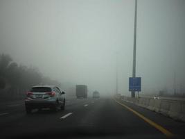 Road in the fog, sign mention keep distance for Motorway-t7.svg photo