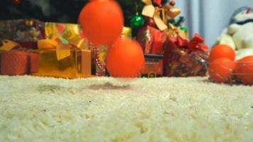 close up of mandarins are falling on the floor near a Christmas tree video