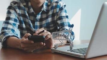 mãos segurando um cartão de crédito e usando o laptop. compras online video